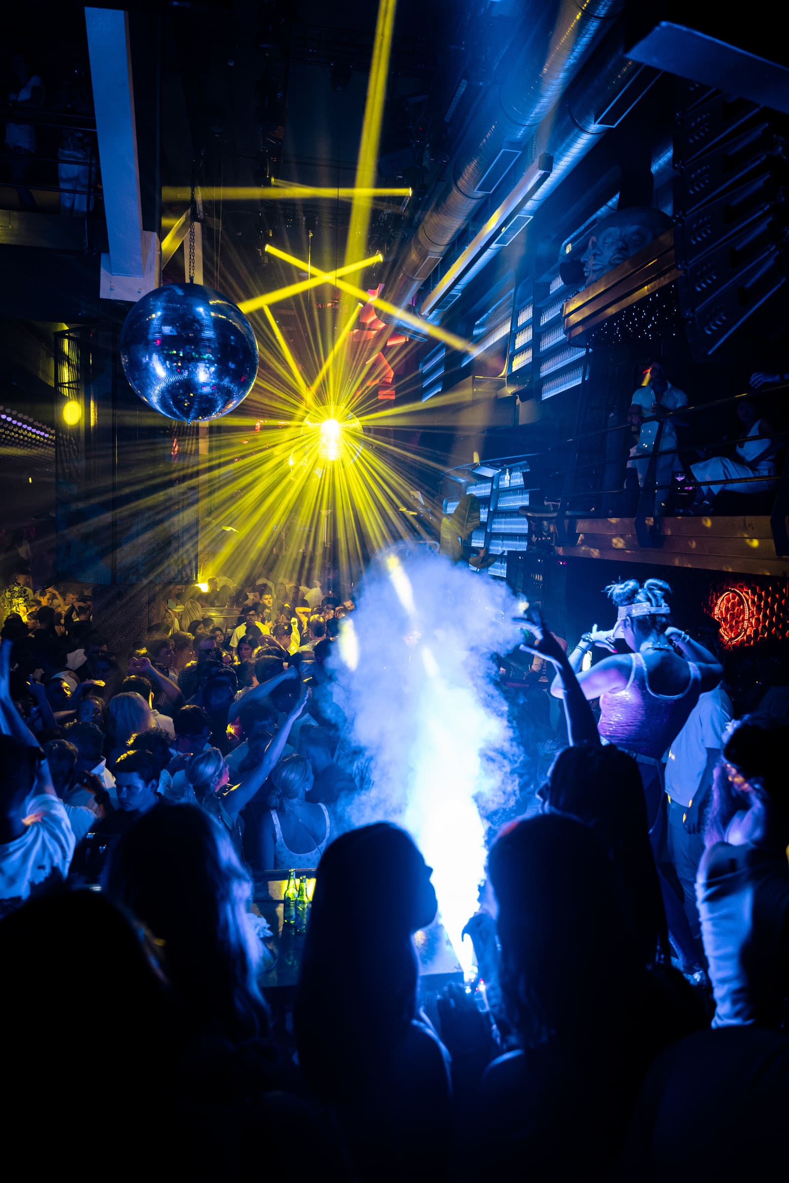 Laser lights and smoke fill a packed Boiler nightclub dance floor.