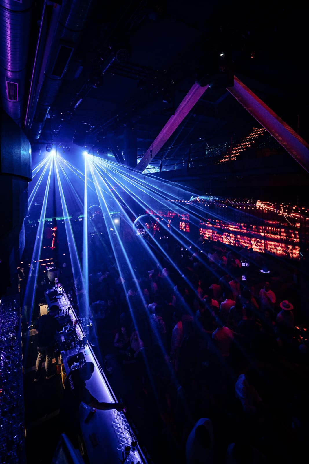 Blue laser lights beam over a crowded nightclub dance floor at Boiler.