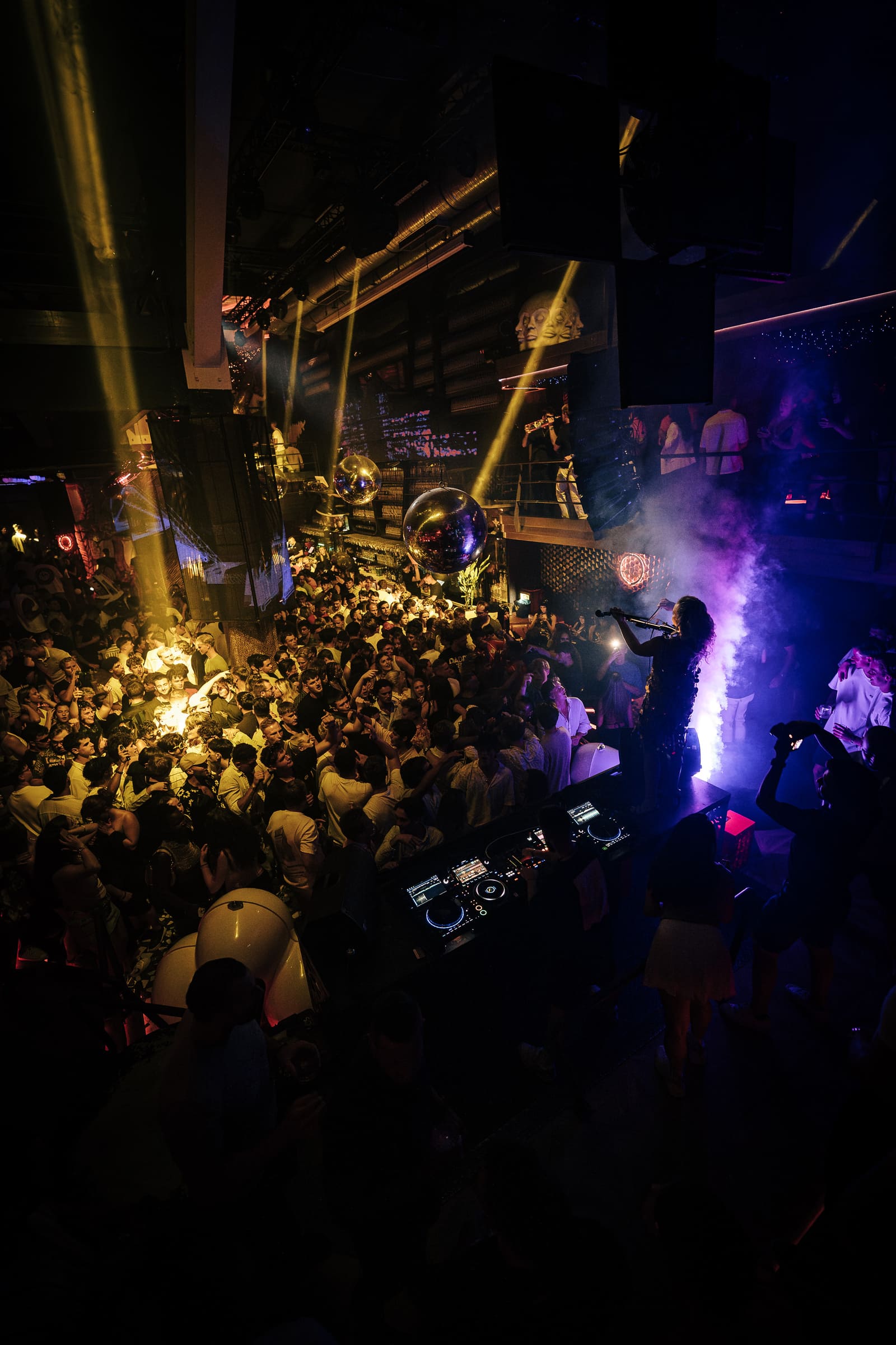 Live violinist performs above crowd at Boiler nightclub.