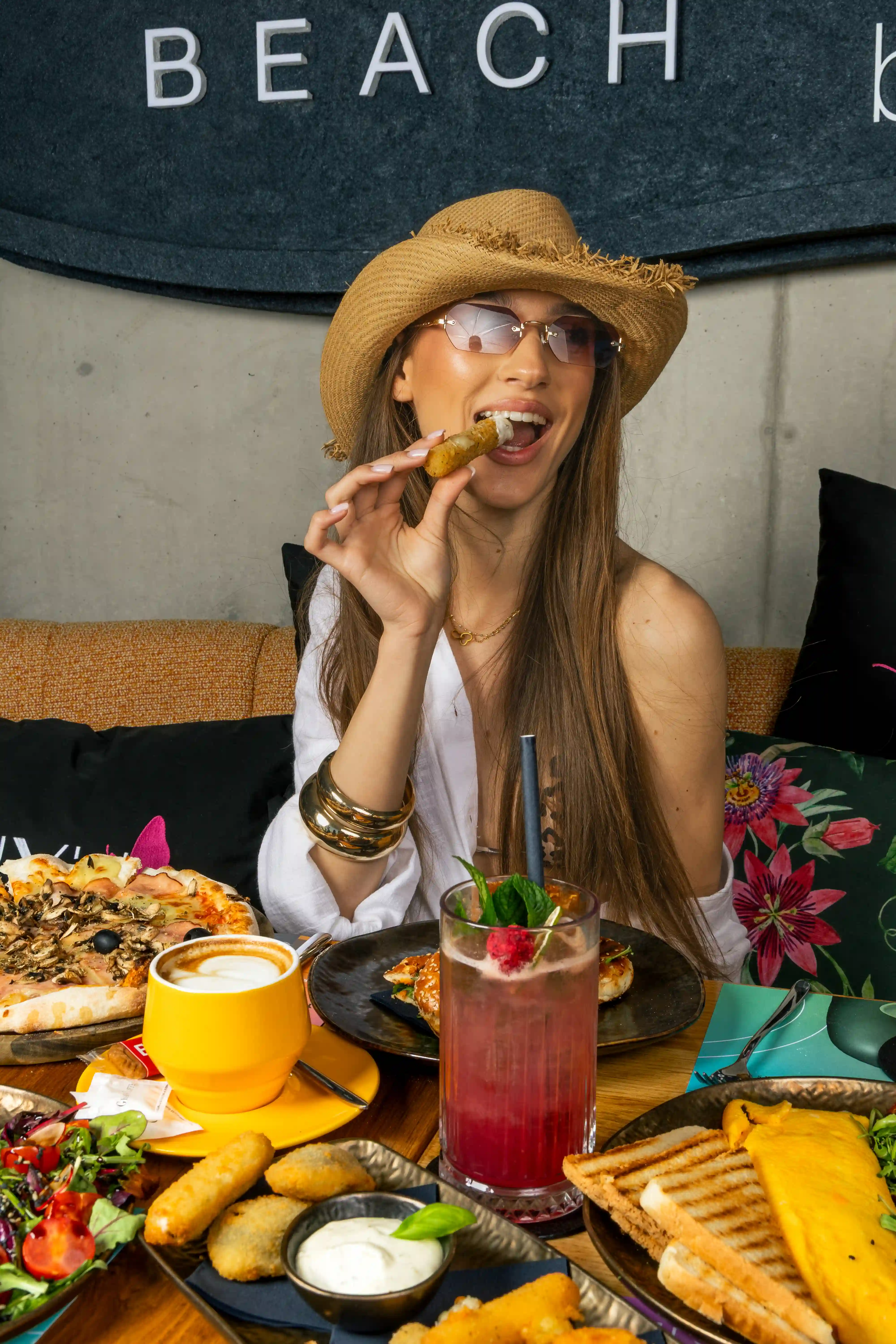Woman enjoying brunch and cocktails at Miyu Beach restaurant.